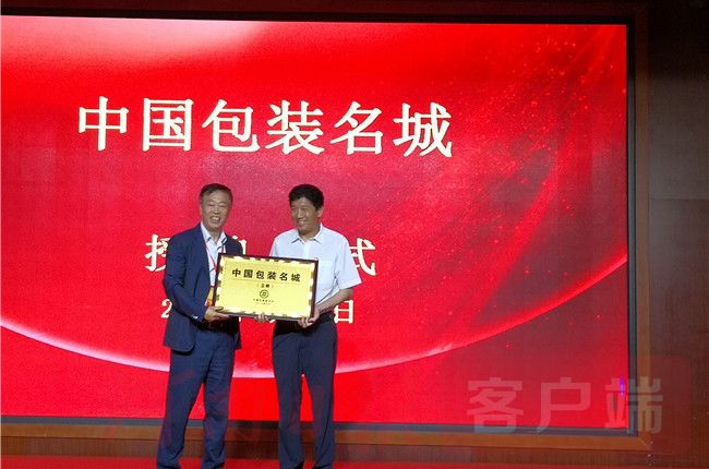 中包装联合会执行会长向卫辉市委书记梁常运递交牌匾